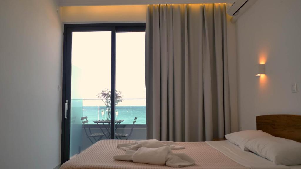 a bedroom with a bed with a view of the ocean at Poseidon Hotel in Rethymno Town