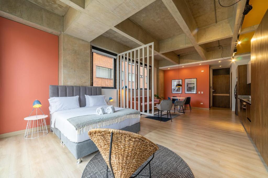1 dormitorio con 1 cama grande en una habitación con paredes de color naranja en Cozy Loft in Parque 93, en Bogotá