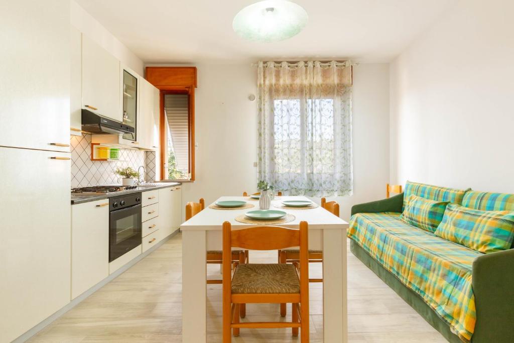 Il comprend une cuisine et un salon avec une table et un canapé. dans l'établissement Appartamento Alide Bilo 2P - MyHo Casa, à Tortoreto Lido