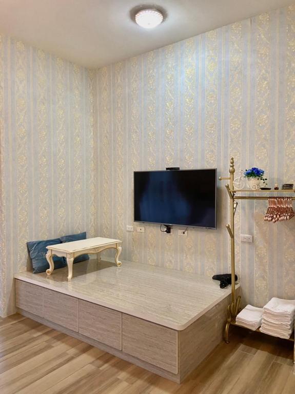 a living room with a tv on a wall at 花蓮漫漫時光電梯包棟民宿 in Hualien City