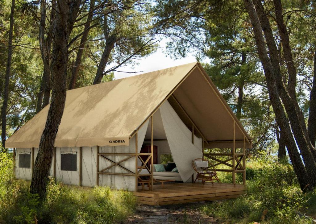 a cabin in the woods with a large roof at Camping Paradiso in Pesaro