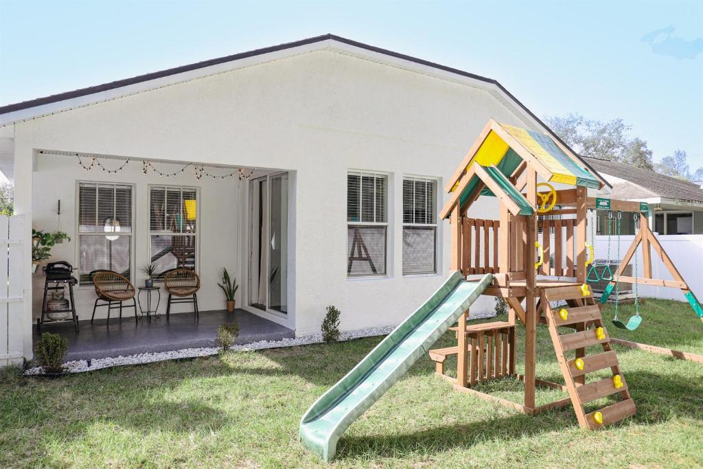 a house with a slide in the yard at Clearwater Bohemian Escape - 7 min to the Beach, BBQ Grill, Playground in Clearwater
