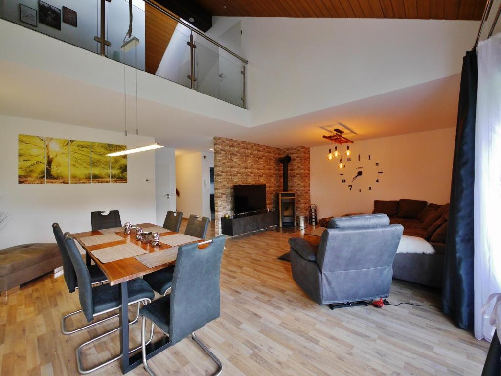 a dining room and living room with a table and chairs at Ferienwohnung Diemelgarten in Willingen