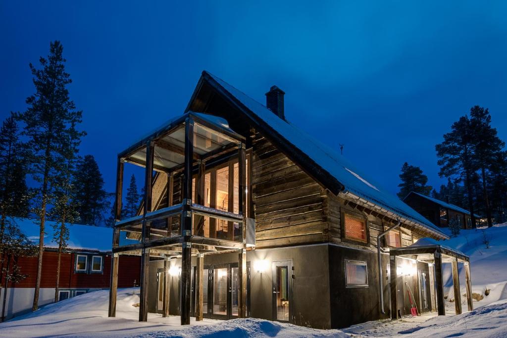 una cabaña de madera en la nieve por la noche en Stora Björnrike en Vemdalen