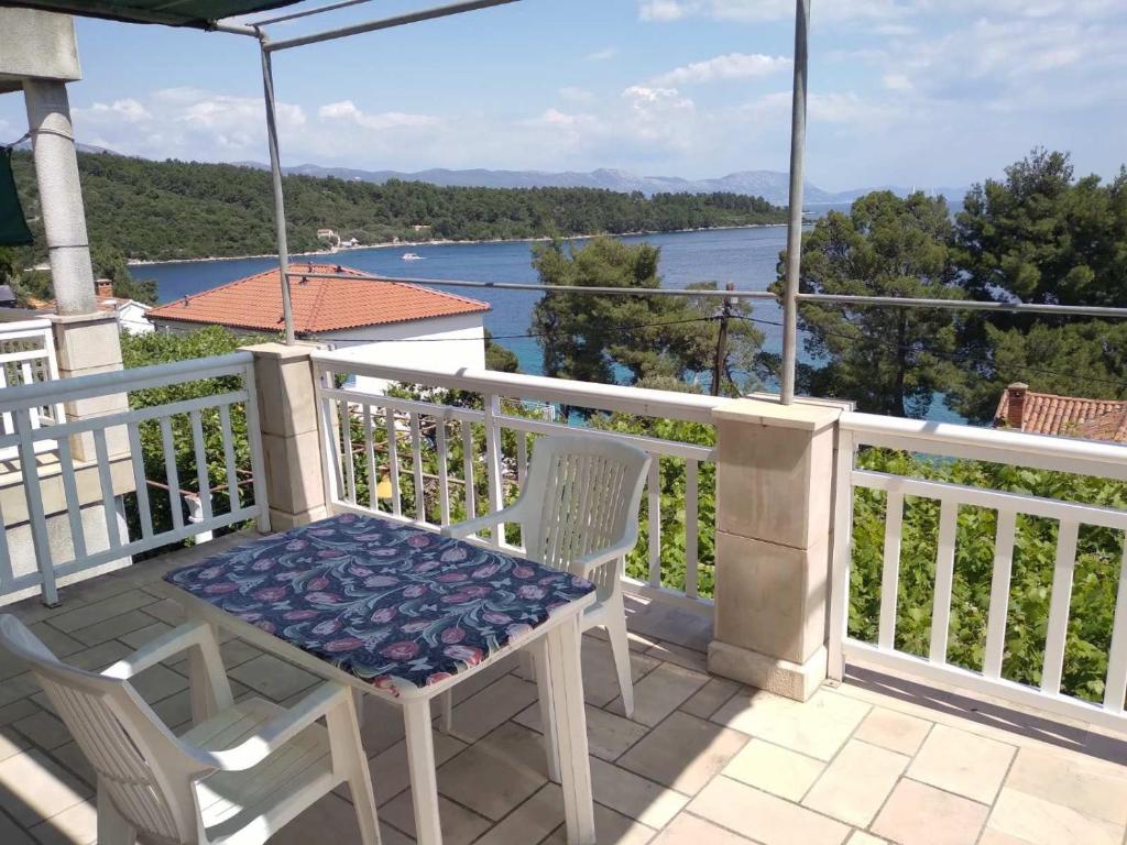 balcone con tavolo, sedie e vista sull'acqua di Apartmani Tereza a Lumbarda (Lombarda)