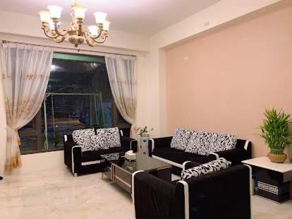 a living room with two couches and a chandelier at 花蓮漫漫時光電梯包棟民宿 in Hualien City