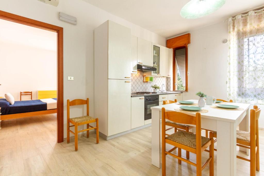 Il comprend une cuisine et un salon avec une table et des chaises. dans l'établissement Appartamento Alide Bilo 1P - MyHo Casa, à Tortoreto Lido