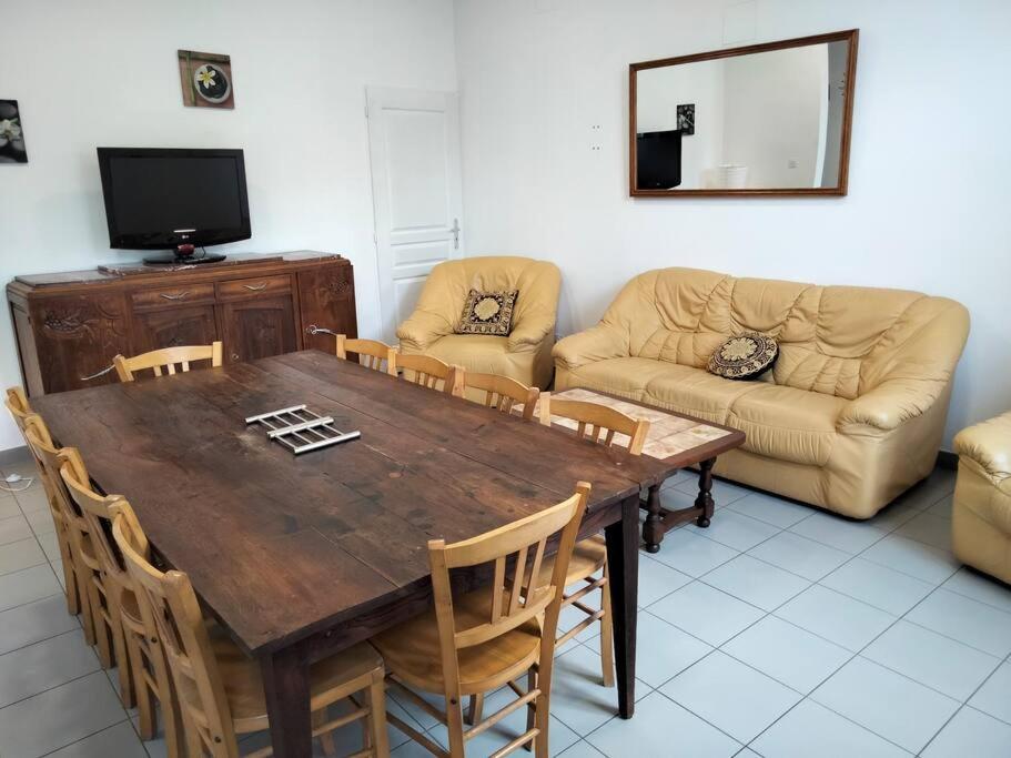 ein Wohnzimmer mit einem Holztisch und einem Sofa in der Unterkunft Gîte de groupe 2 à 12 personnes in Guillon