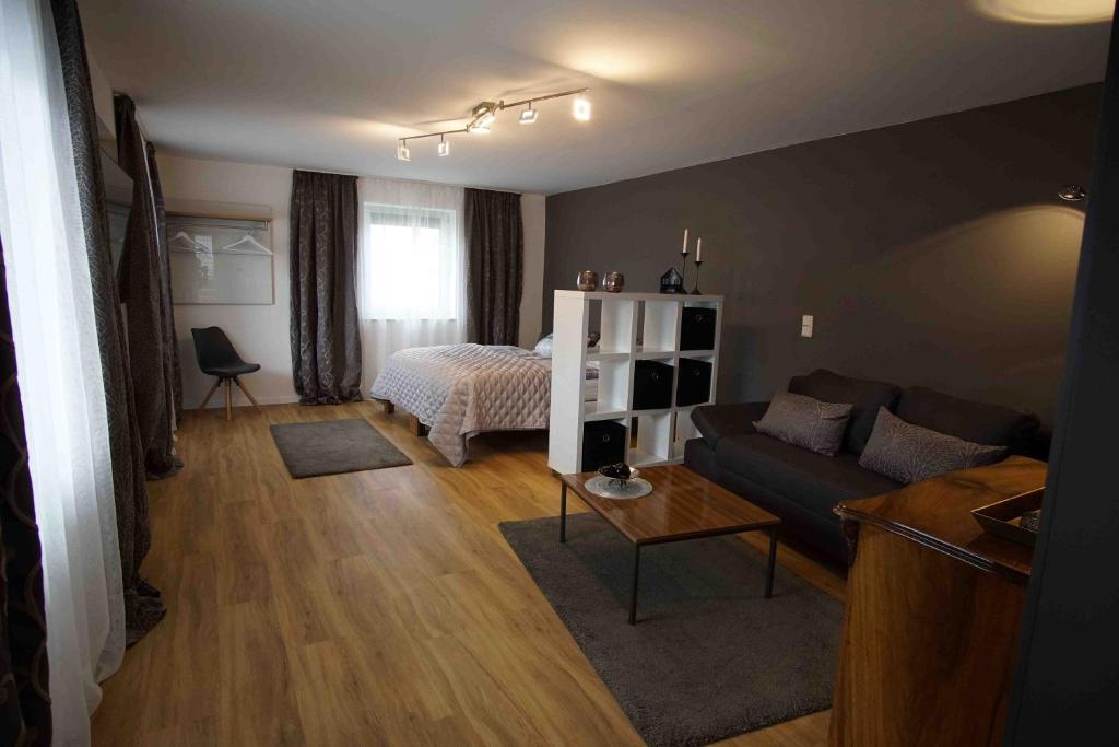 sala de estar con sofá y cama en Fewo Nüßle, en Bad Grönenbach