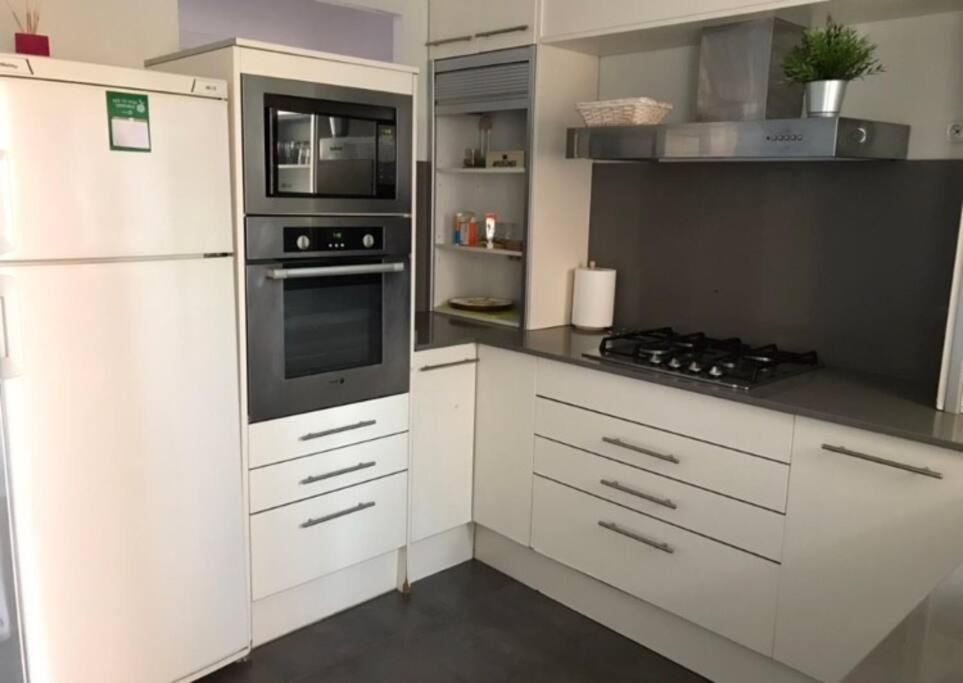 uma cozinha com armários brancos e um forno com placa de fogão em Premia de Mar, Maresme, Barcelona em Premià de Mar