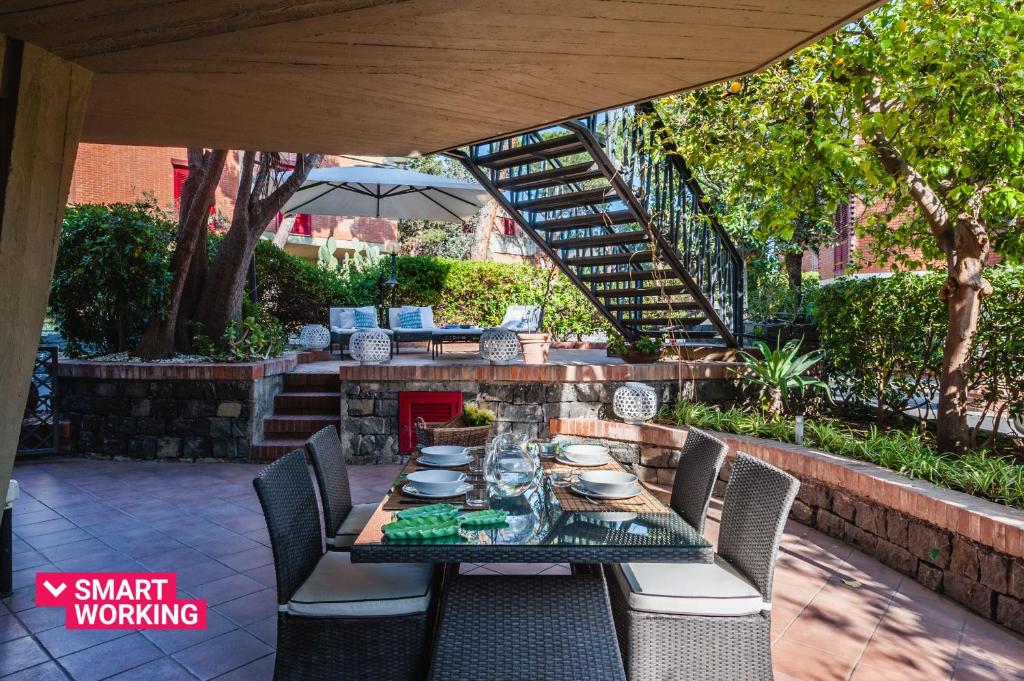 een tafel en stoelen op een patio met een trap bij Casa Magnolia by Wonderful Italy in Aci Castello