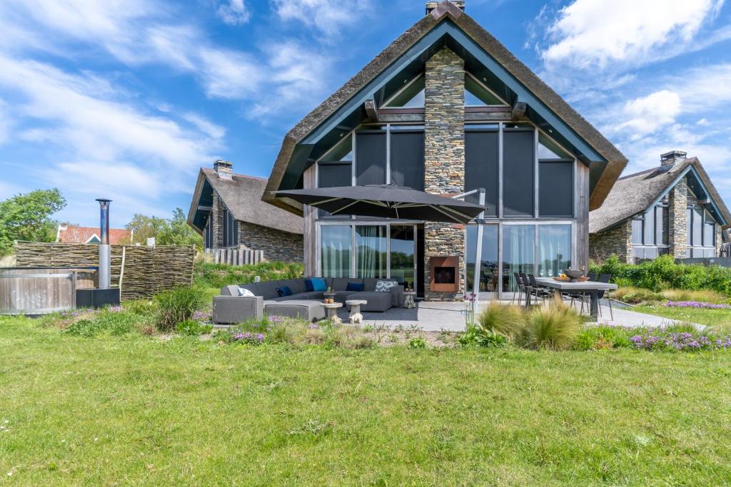 une maison avec une véranda et un toit dans l'établissement Buytenplaats Villa 191, à De Koog