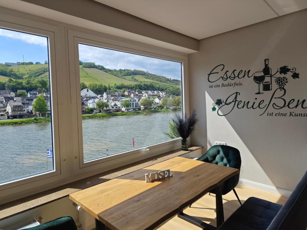 uma sala de jantar com uma mesa e uma grande janela em Ferienwohnung Schöne Aussicht em Zell an der Mosel