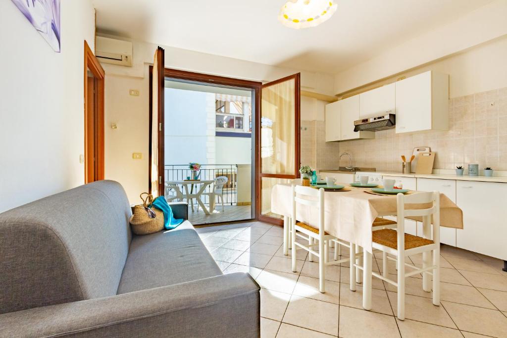 Il dispose d'une cuisine et d'un salon avec un canapé et une table. dans l'établissement Appartamento Dalila Bilo 1P - MyHo Casa, à Tortoreto Lido