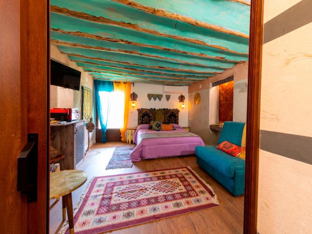ein Schlafzimmer mit einem Bett, einem Sofa und einem Spiegel in der Unterkunft Domus Lapidis - Medina in Bogarra