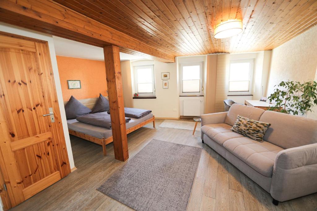 a living room with a couch and a bed at Gästehaus Villa Wernz in Albisheim