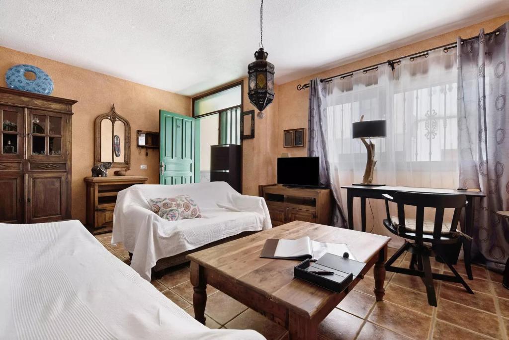 een woonkamer met 2 bedden en een tafel bij Casa Manus in Alcalá