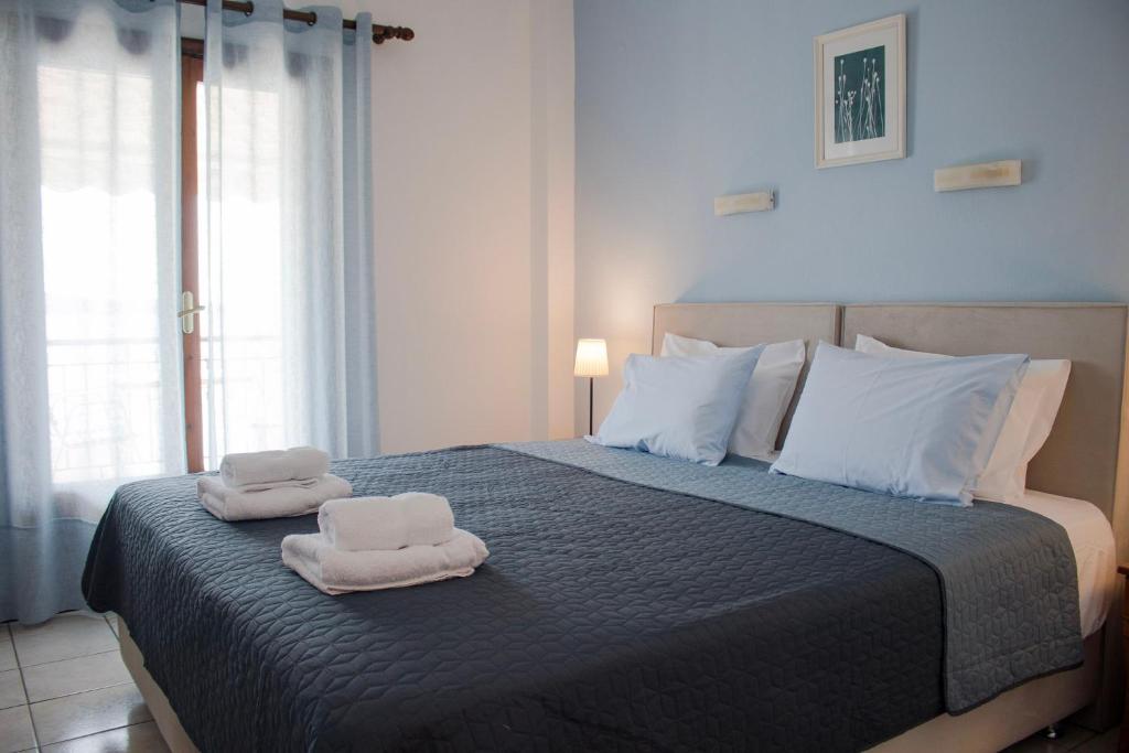 a bedroom with a bed with towels on it at Glaros Blue in Neos Marmaras