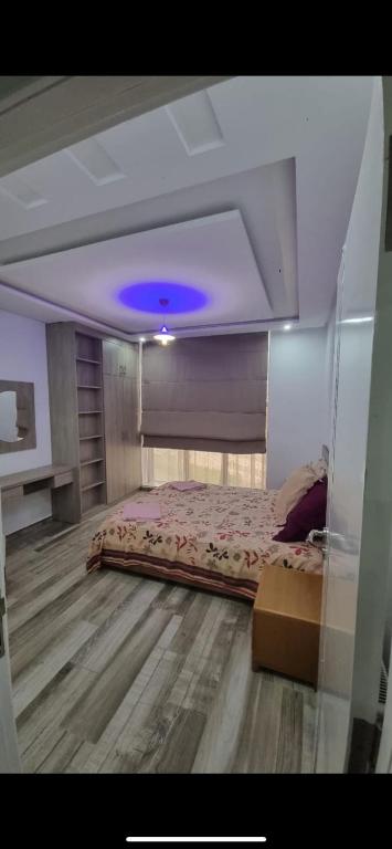 a bedroom with a bed with a purple ceiling at Stylish City Apartment in Monastir