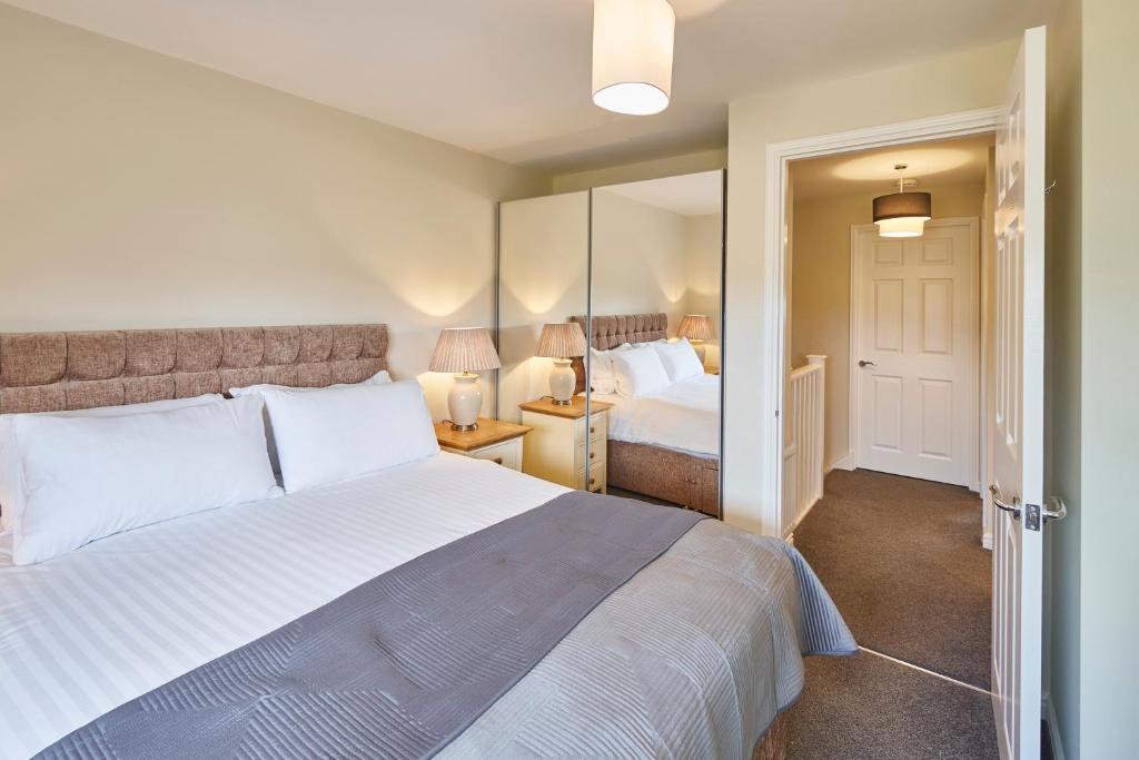 sypialnia z dużym białym łóżkiem i lustrem w obiekcie Host & Stay - Town House w mieście Seaham