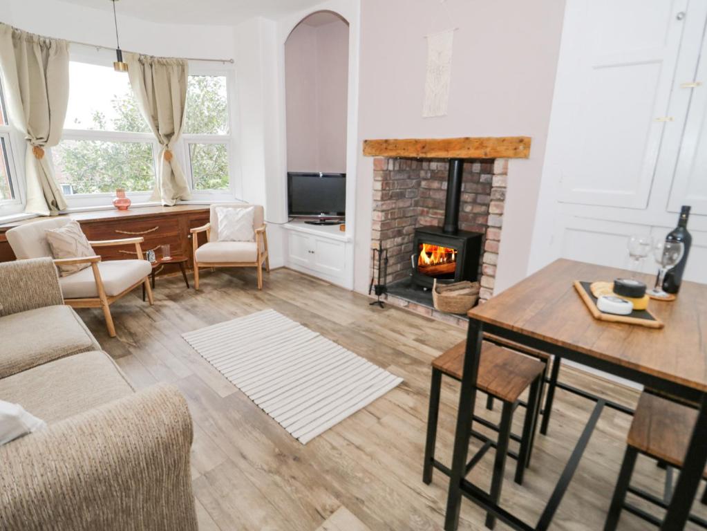 a living room with a table and a fireplace at Ty Arth in Llandudno