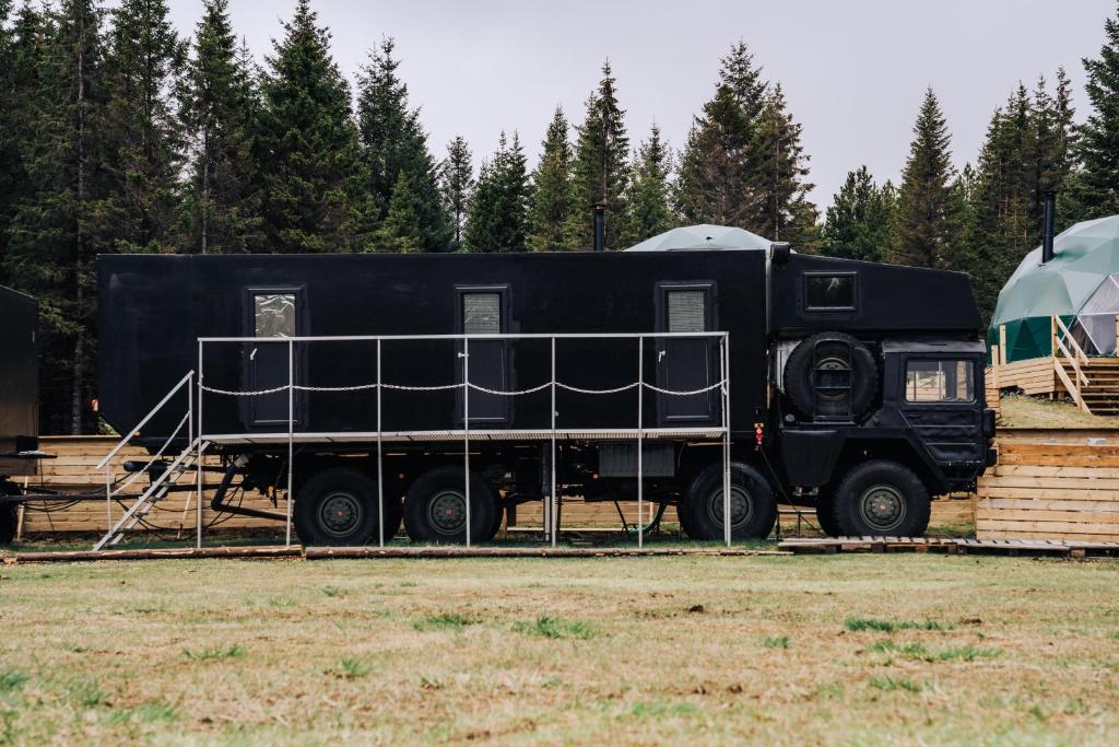 Ein schwarzer Truck parkt auf einem Feld. in der Unterkunft Golden Circle Truck Hotel in Selfoss