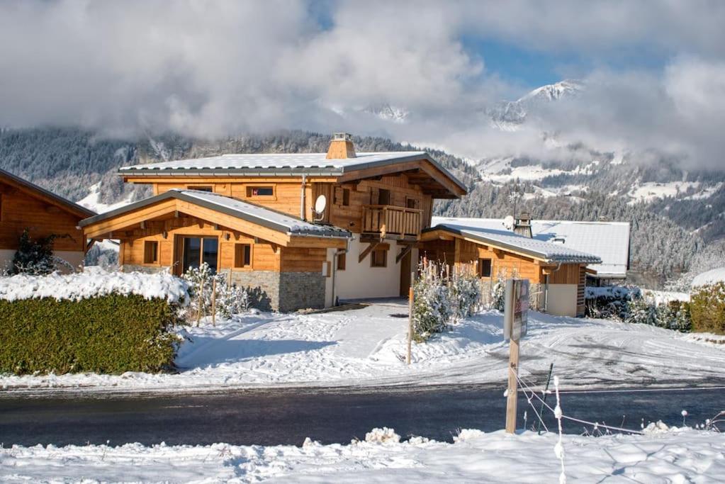 a log home in the snow with mountains in the background at chalet l'Orignal 145m2, 10pers, pied de piste,SPA in Notre-Dame-de-Bellecombe
