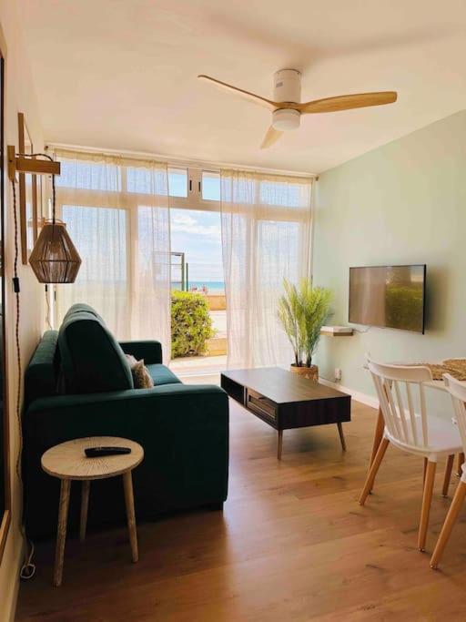sala de estar con sofá verde y mesa en Apartamento Boutique en la Playa, en La Pineda