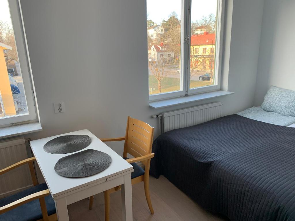 a room with a bed and a table and a bed and window at Apartment in Bromma close to Stockholm City in Stockholm