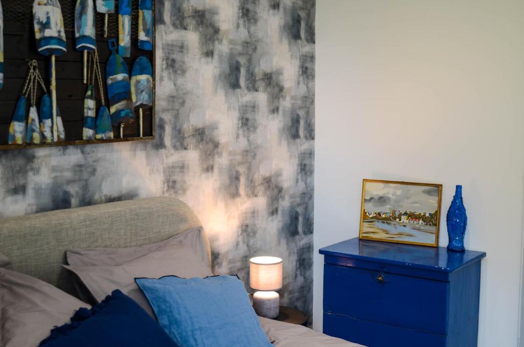 - un salon avec un canapé et une armoire bleue dans l'établissement Le Quai Huppé, voie 2, à Noyelles-sur-Mer