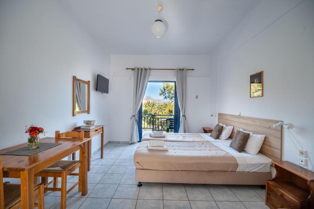 a bedroom with a bed and a table and a desk at Maria's Studios in Frangokastello