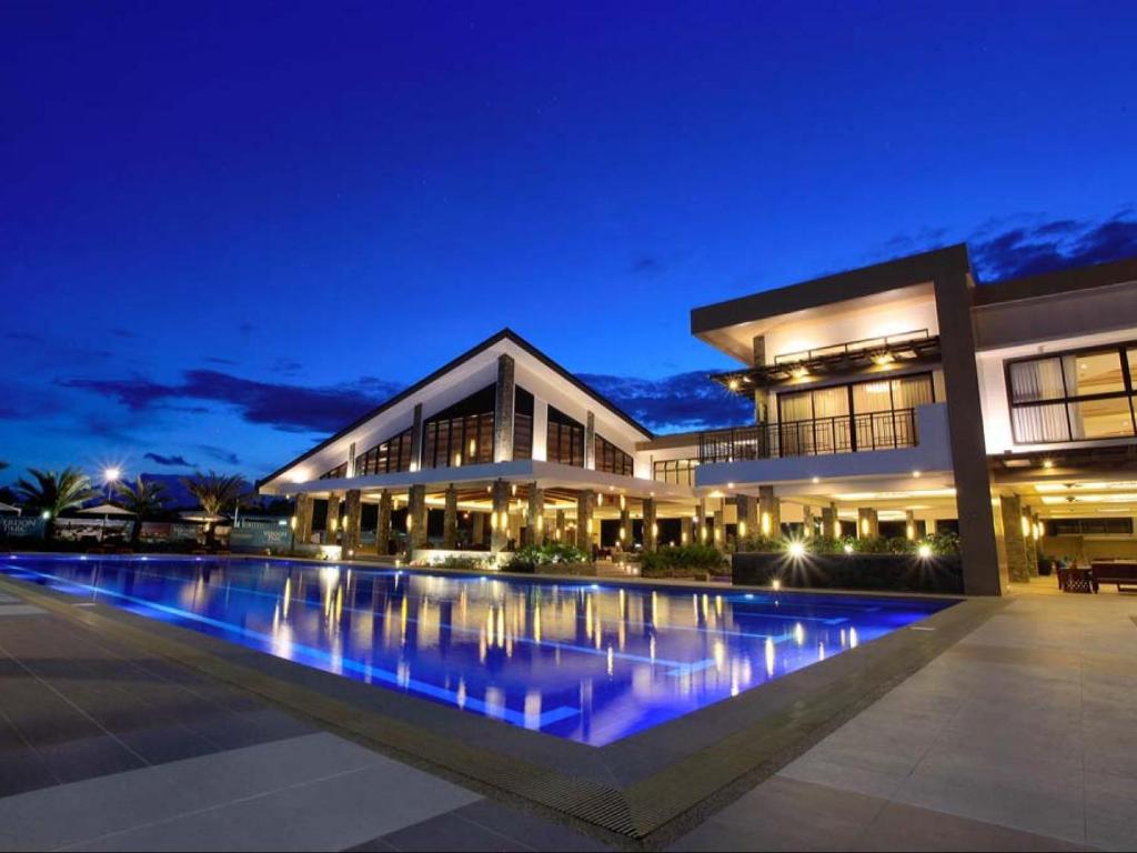 un edificio con una piscina delante de él por la noche en Verdon Parc Condo 1 Bedroom, en Davao City