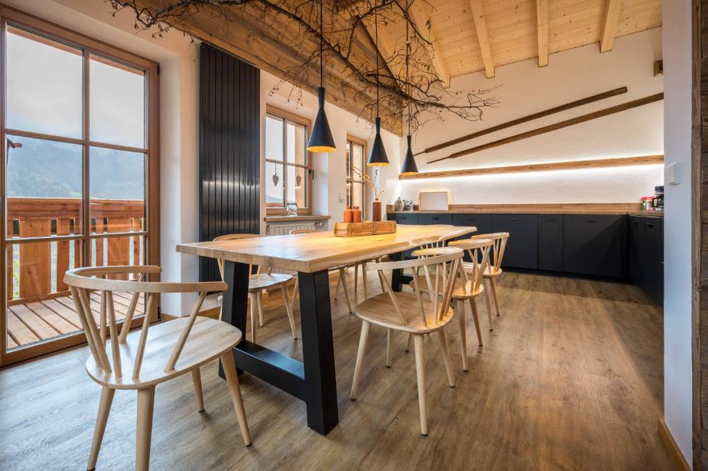 Valentin36 Apartment Ritten في فونيس: مطبخ وغرفة طعام مع طاولة وكراسي خشبية