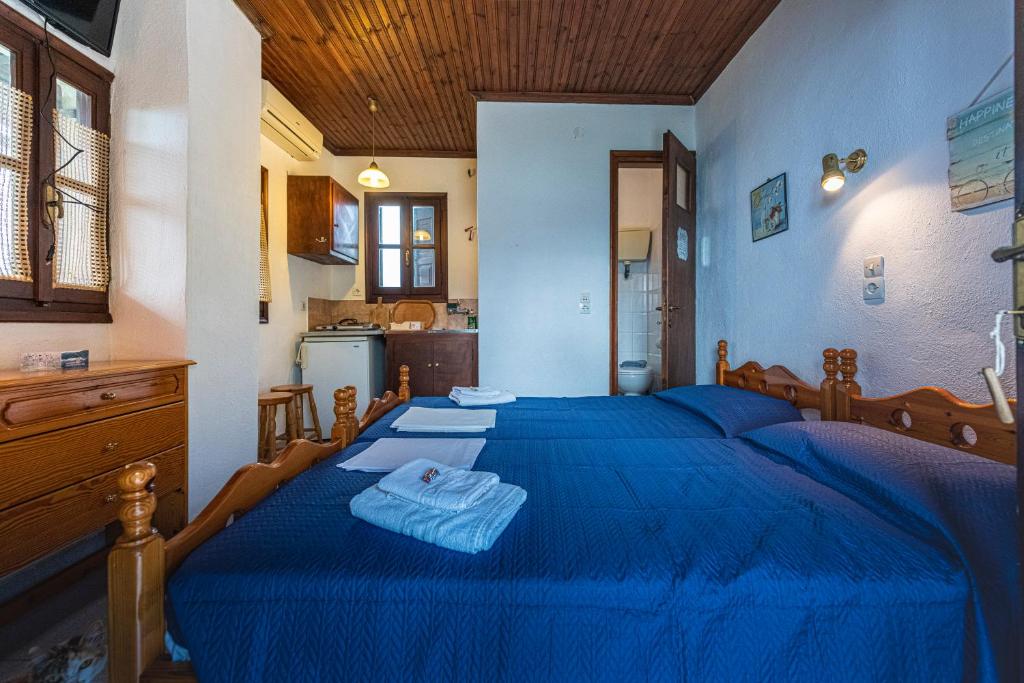Un dormitorio con una cama azul con toallas. en SunRiseStudiosPapanero, en Damouchari