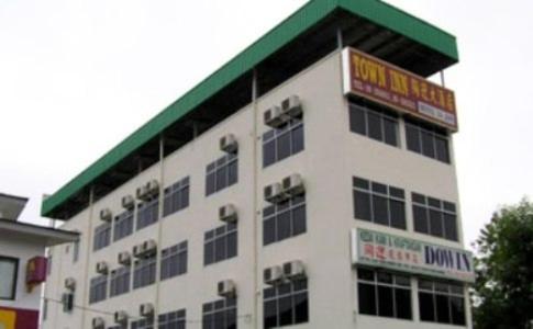 a large white building with a green roof at Town Inn Hotel in Jerantut