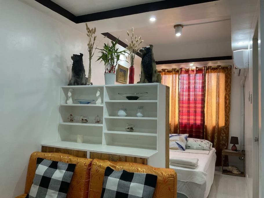 Antipolo Staycation & Transient Affordable Condo Unit By Myra في أنتيبولو: غرفة نوم مع سرير ورفوف في غرفة