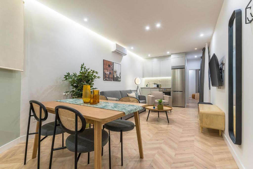 a dining room and living room with a table and chairs at Limehome Madrid Calle de Luchana - estancia temporal in Madrid