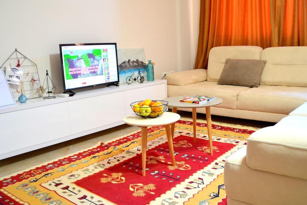 uma sala de estar com um sofá e uma televisão em Sunny Flat in the Center of Tirana, 2 min. walk em Tirana