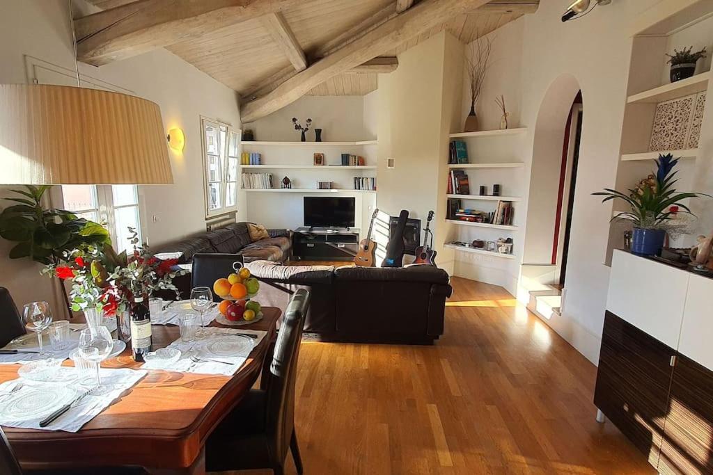 ein Wohnzimmer mit einem Tisch und einem Sofa in der Unterkunft La Terrazza Di Bene Arancio in Lucca