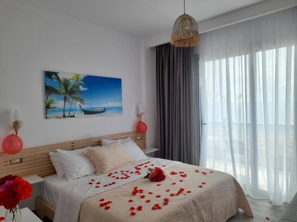 um quarto com uma cama com rosas vermelhas em Anxhelos Hotel em Himare