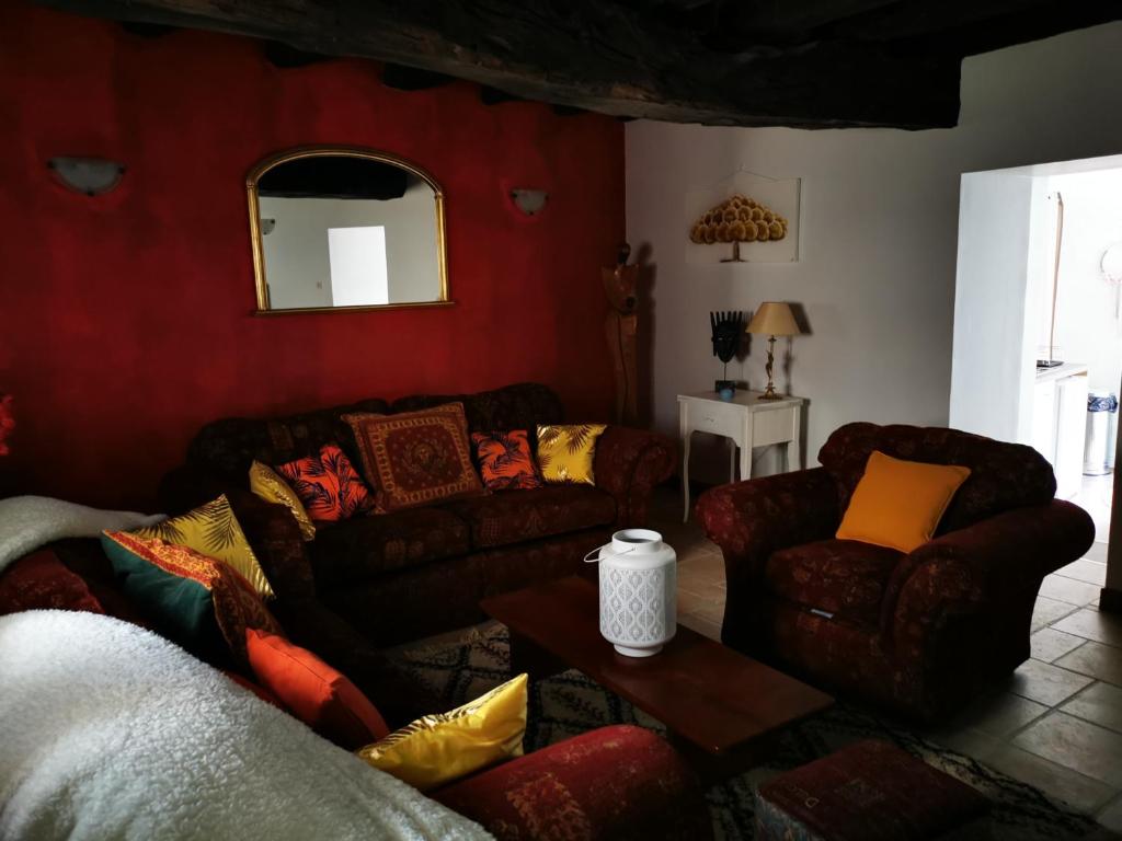 uma sala de estar com sofás e um espelho em Maisonnette em Bourneau