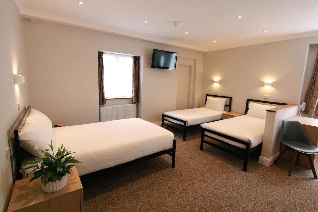 a hotel room with two beds and a tv at Lords Hotel in London