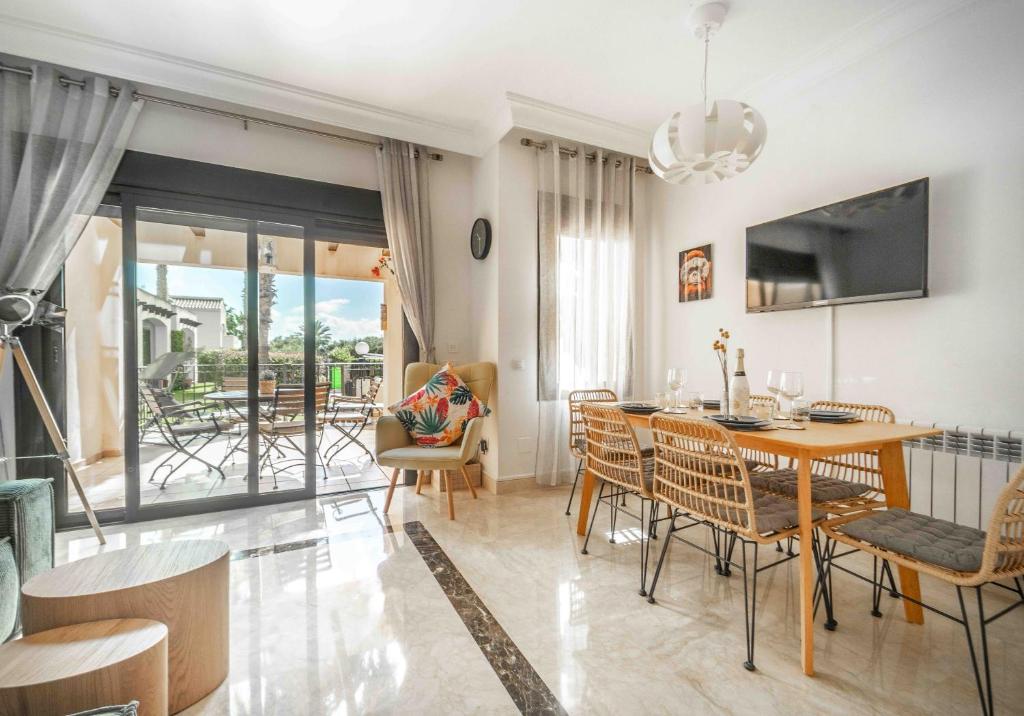 a living room with a dining room table and chairs at Casa de la vida - Roda Golf in Roda