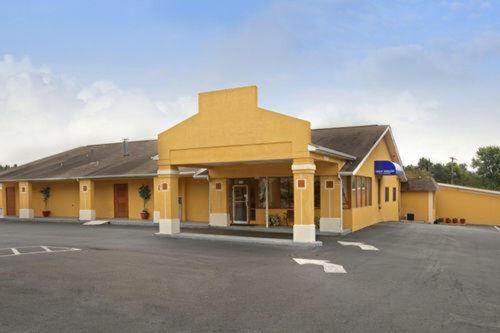 a yellow building with a parking lot in front of it at Governors INN Shelby in Shelby