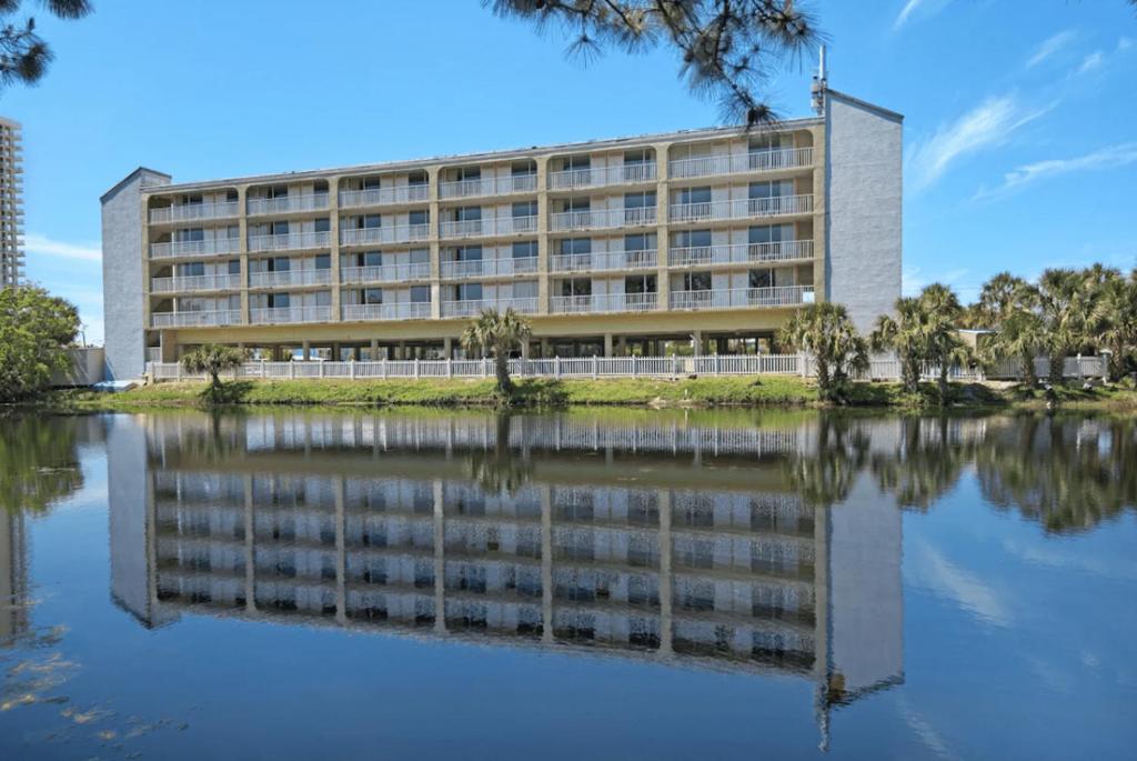 un edificio de oficinas con su reflejo en el agua en Baymont by Wyndham Panama City Beach en Panama City Beach