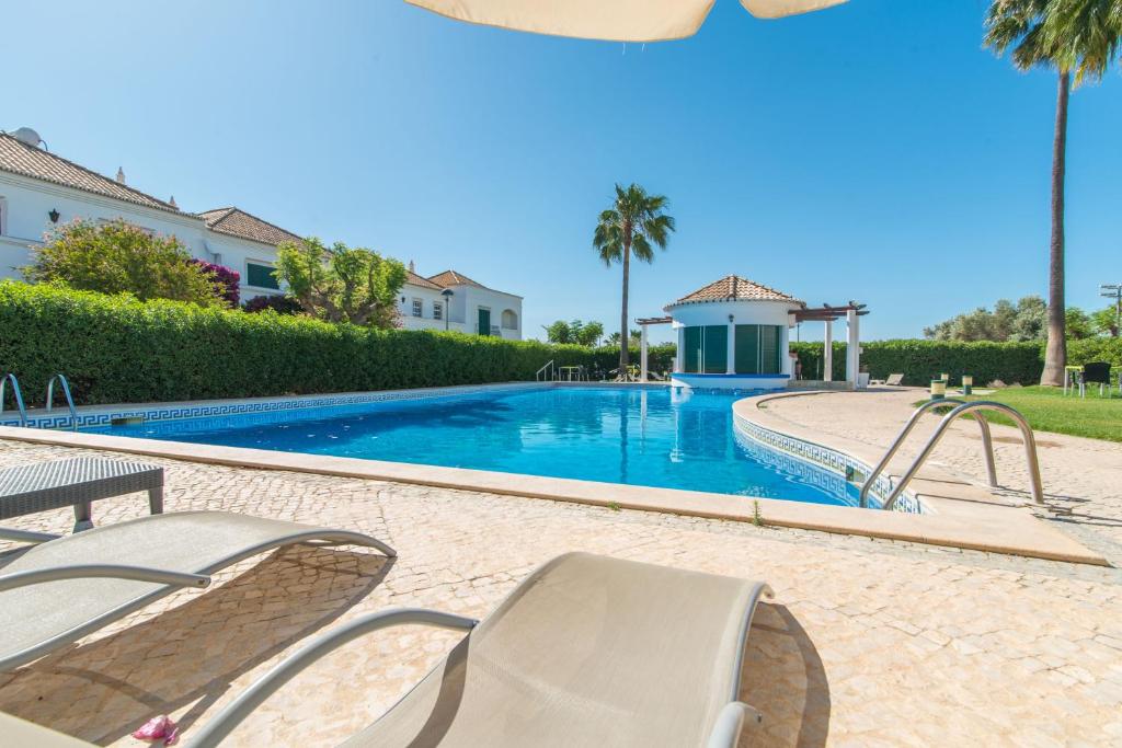 卡巴納斯·德·塔維拉的住宿－Casa Oceanus - 2BDR House w Pool & Balcony，一个带两把椅子和滑梯的游泳池