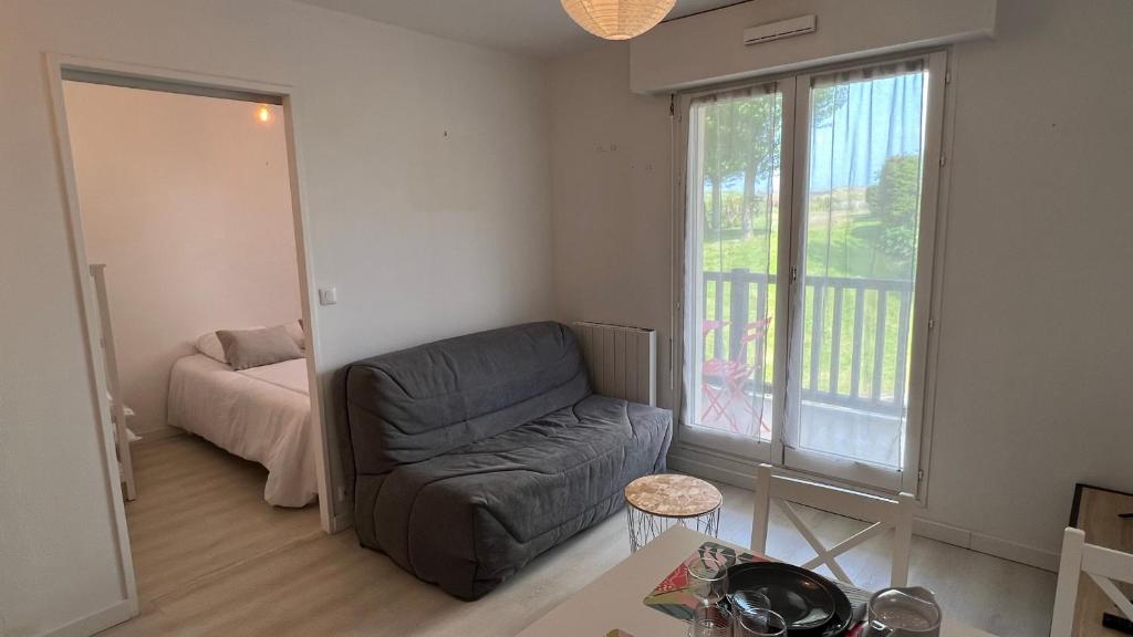 un salon avec un canapé et une fenêtre dans l'établissement Appartement 2 pièces en rez-de-chaussée dans résidence avec accès direct à la plage, à Cabourg