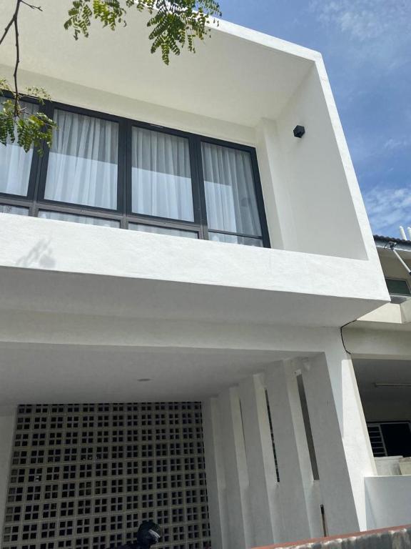 a white house with black windows on top of it at Timurahaus in Kajang