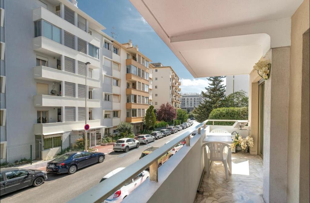 einen Balkon mit Blick auf eine Straße mit Autos in der Unterkunft Charmant 2 pièces à deux pas de la Croisette in Cannes
