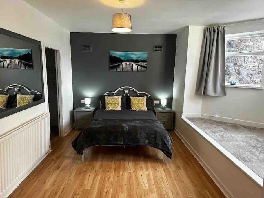a bedroom with a bed and two night stands at Netherby Grange Garden Apartment with Sea Views in Llandrillo-yn-Rhôs